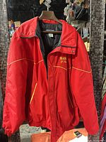 Front view of red jacket on hanger showing overall design and pockets