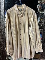 Full view of striped CFH long sleeve shirt on hanger