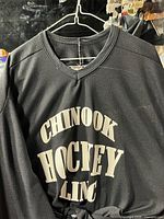 Front view of black jersey showing full garment and printed text