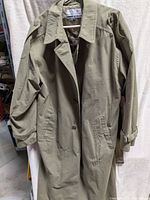 full view of trench coat front showing color, length, pockets, epaulettes, sleeve straps