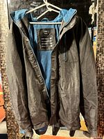 Full view of F&F black jacket on hanger, front open