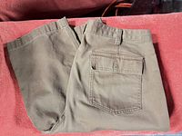 Full view of folded beige capri pants showing overall fabric and color