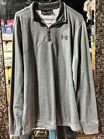 Front view of grey Under Armour quarter-zip pullover on hanger