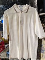 Front view of cream short-sleeve polo on hanger