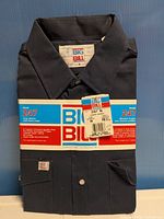 Front view of folded navy Big Bill work shirt with wrap band and hang tag visible