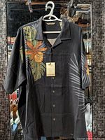 Front view of shirt displaying tropical print, buttons and tags