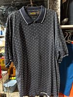 Front view of navy geometric print Pin Hi Arrow polo shirt