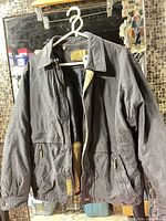 Front view of Rainforest dark charcoal jacket on hanger