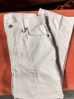 Full view of light beige Simon Chang jeans folded