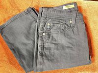 Full view of folded charcoal grey pants