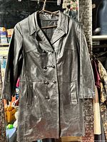 full front view of black leather long coat on hanger