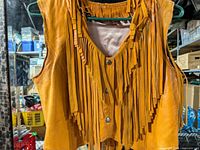 Front view showing leather body, long fringe and snap closure