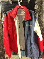 Front view of tri-color Hartwell Slot Olympics windbreaker jacket on hanger