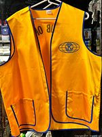 Front view of yellow Kiwanis vest with logo and pockets