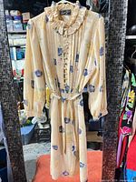 Full view of cream floral pleated dress with belt