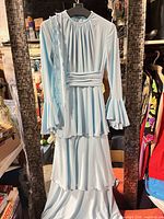 Full view of light blue tiered dress on hanger