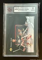 Front of KSA-slabbed card showing label with grade 8 NMM and action photo