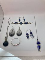 All eight jewellery pieces laid out: two necklaces, two bracelets, three pairs of earrings