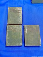 Three green clothbound Dutch Dumas volumes laid out