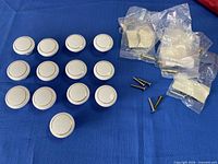 Group of 13 white ceramic knobs and 11 screws in bags