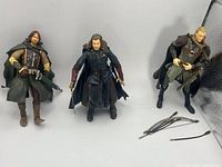 Front view of three LOTR action figures with accessories