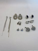 All seven pairs of rhinestone earrings laid out