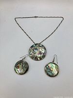 Front view of necklace with pendant and matching earrings showing abalone inlay