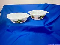 Two white oval Pyrex casseroles with Market Garden pattern