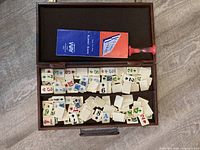 open case showing tiles, instruction booklet and red rack