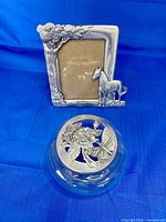 Glass bowl with pewter butterfly lid in front of pewter horse photo frame