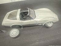 Top view of silver Corvette model showing missing wheel and roof panels