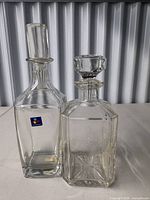 Front view of both glass decanters with stoppers