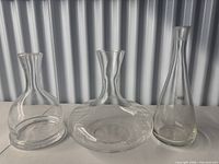 Three clear glass decanters side by side showing overall shapes