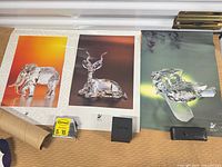 Three posters: elephant, antelope, crystal figure on green background