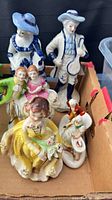 Group view of all five porcelain figurines in box