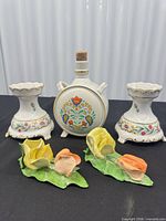 Group view showing flask, two pedestals and two flower figurines