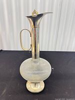 Full view of decanter showing glass body, silver-plate neck, handle and base