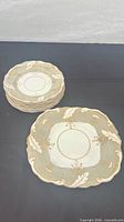 Stack of six round dessert plates and square cake plate showing pattern