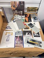 Spread of assorted Swarovski brochures, certificates, magazines on table