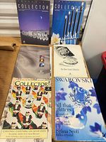 Overview of six Swarovski magazines and brochure laid out on table
