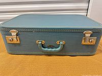 Front view of suitcase showing handle, badge, latches