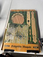 Opened box showing wooden parts, clock dial and hardware of the kit