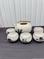 Front view of teapot and five bowls showing complete set