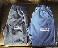 Both sweatpants folded side by side showing colours and logos