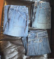 Three folded denim skirts on couch