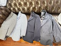 Four boys suit jackets laid out on sofa