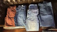 Four pairs of jeans laid out showing color and style