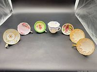 Seven assorted bone china teacups displayed