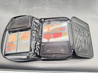 Open black makeup case showing palettes and compartments