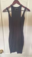 Full view of black bodycon mini dress on hanger